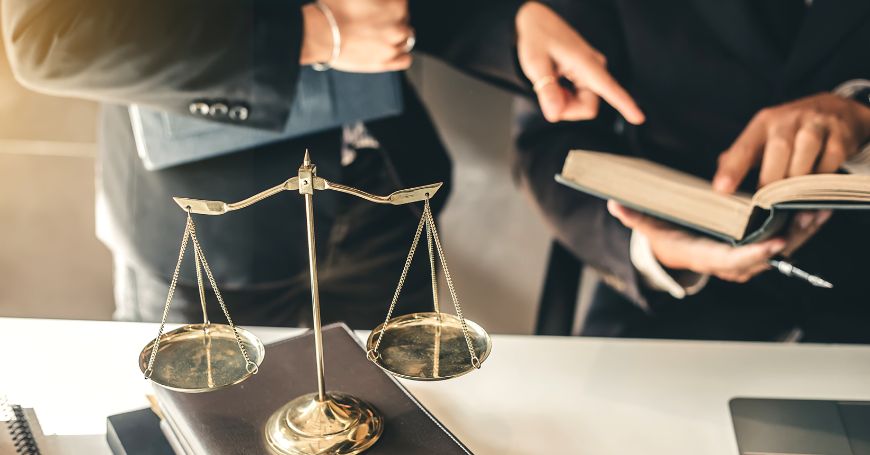 bilancia con in sfondo due avvocati che si informano sulla convenzione contro le doppie imposizioni tra italia e spagna