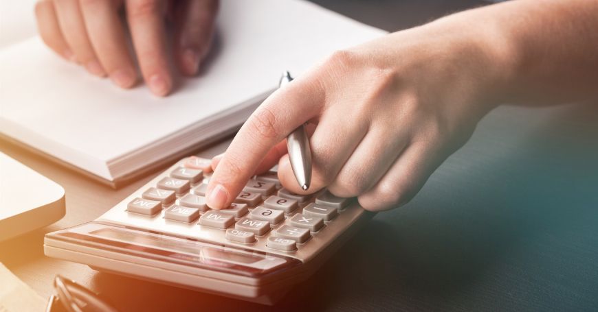 persona digita su una calcolatrice per calcolo tasse per evitare la doppia imposizione sulle tasse in italia e spagna