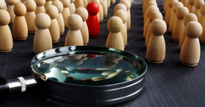 pawns symbolizing employees and one is red as symbol of the one hired