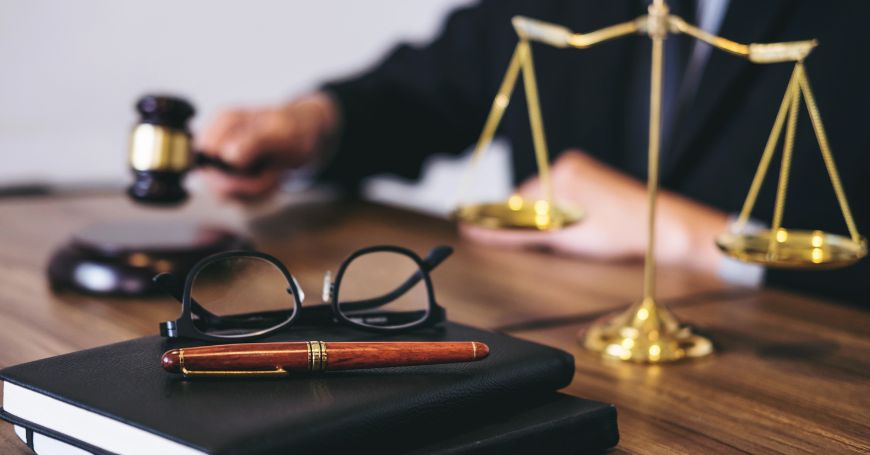 Bilancia dorata della giustizia con un martelletto giudiziario su una scrivania, simbolo del processo di esproprio in Spagna.
