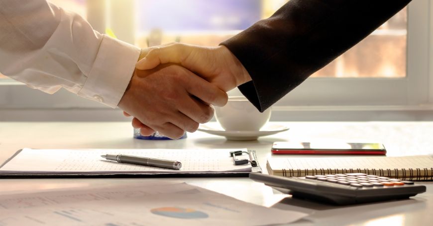 Stretta di mano tra imprenditori in un ufficio, simbolo di accordo per costituire una società di persone in spagna.