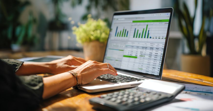 Investitore che analizza i dati sul reddito da dividendi e sulla ritenuta fiscale su un laptop per la tassazione dei dividendi in Spagna