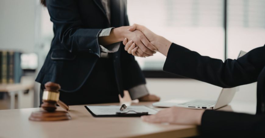 Stretta di mano tra professionisti dopo accordo legale su controversie commerciali in spagna
