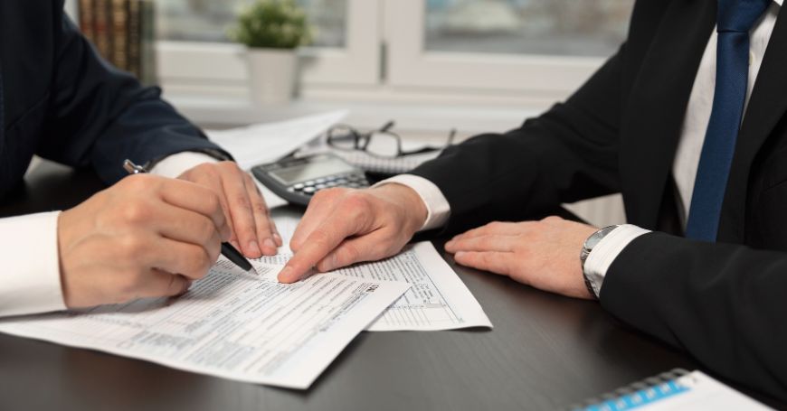 Two professionals reviewing documents at a desk, illustrating EOR arrangements and Beckham Law eligibility in Spain.